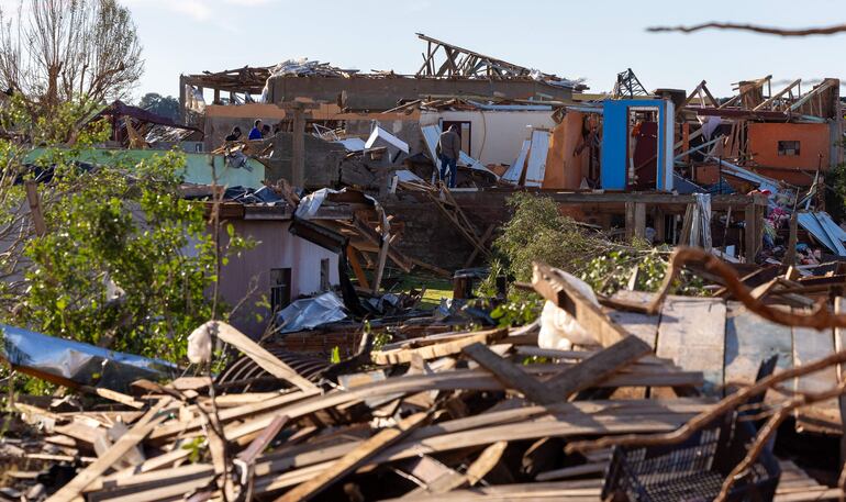 Personas caminan en medio de escombros este domingo en una zona afectada por un tornado en la ciudad de Rio Bonito do Iguaçu, estado de Paraná (Brasil). 