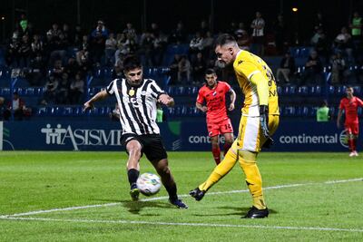 El arquero Santiago Rojas (d), jugador de Nacional, rechaza el balón ante la presión de Néstor Giménez, futbolista de Libertad, en el partido por la segunda fecha del torneo Clausura 2024 del fútbol paraguayo en el estadio Luis Alfonso Giagni, en Villa Elisa, Paraguay.