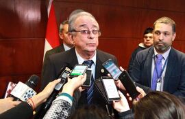 Dr. Raúl Torres Kirmser en el centro, surrounded by reporters con micrófonos y cámaras, atención plena en la conferencia.