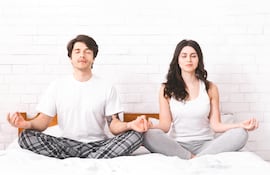 Pareja practicando meditación y respiración consciente.