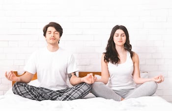 Pareja practicando meditación y respiración consciente.