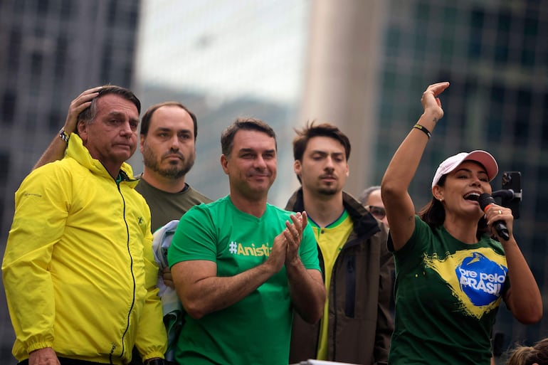 (ARCHIVO) Michelle Bolsonaro (D) habla junto a su esposo, el expresidente de Brasil Jair Bolsonaro (I), y sus hijos Carlos , Flavio (C) y Renan, durante un mitin en la Avenida Paulista en Sao Paulo, Brasil, el 6 de abril de 2025. Un juez de la Corte Suprema autorizó el 11 de septiembre una investigación contra Flavio Bolsonaro por posibles delitos 'en el contexto del financiamiento de la producción' de Dark Horse, una película sobre su padre, el expresidente Jair Bolsonaro (2019-2022)