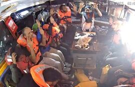 Fotografía facilitada por la Coalición de la Flotilla de la Libertad (FFC), de la tripulación del buque Madleen, con destino a Gaza, sentada en la embarcación, con chalecos salvavidas y las manos en alto, en el Mediterráneo, este lunes.