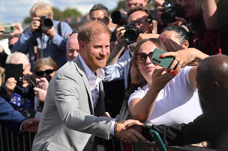 El príncipe Harry se toma fotos con el público luego de visitar el estudio de grabación comunitario en Nottingham.