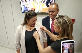 Lizarella Valiente, vice líder de la bancada oficialista en el Senado le coloca el pin del Partido Colorado a Zenaida Delgado.
