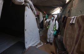 Un funcionario palestino desinfecta tiendas en el campo de refugiados de Jan Yunis, en Gaza.
