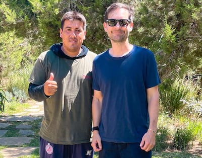 Richard Alfredo Aguilar Delgado en camiseta gris y Tobey Maguire en camiseta azul y gafas, sonriendo y posando en un entorno verde.