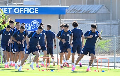 Entrenamiento de ocho jugadores de la selección paraguaya, vistiendo camisetas Puma, saltando sobre conos de colores en un campo deportivo.