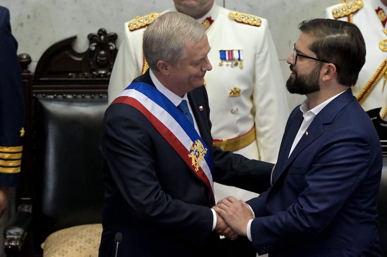 El presidente de Chile, José Antonio Kast (d) recibe la banda presidencial del saliente mandatario, Gabriel Boric.