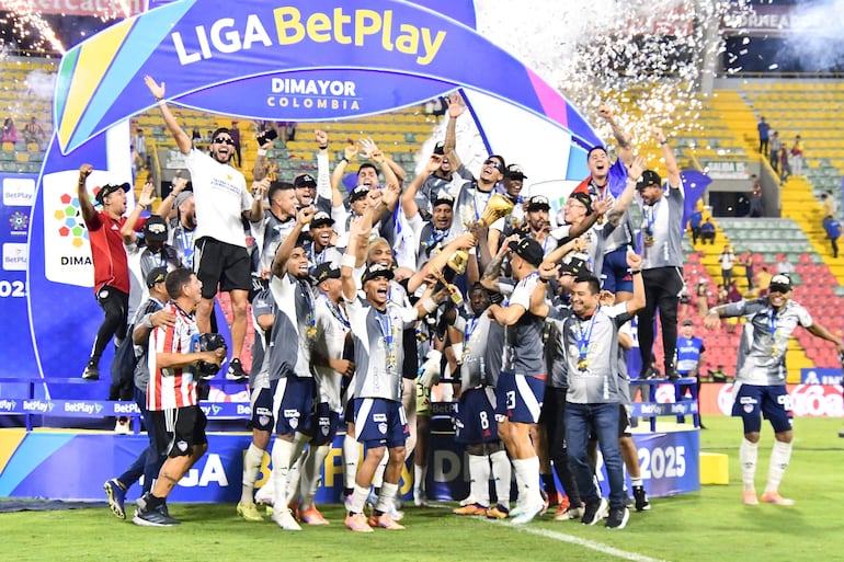 Los jugadores de Junior celebran con el trofeo de campeón del torneo Finalización 2025 después de superar 1-0 a Deportes Tolima en la revancha de la final en el estadio Manuel Murillo Toro, en Ibagué, Colombia.
