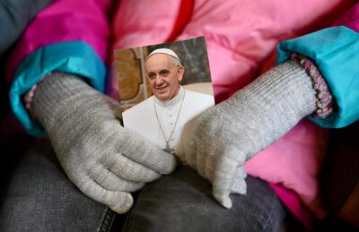 Una persona sostiene una imagen del papa Francisco mientras fieles asisten a una oración del Rosario por la salud del pontífice en la Plaza de San Pedro en la Ciudad del Vaticano, 03 de marzo de 2025.