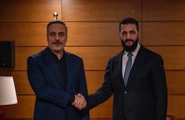 El ministro turco de Exteriores, Hakan Fidan (d) saluda al presidente de Siria, Ahmed al Shara'a, durante un foro diplomático en Turquía.