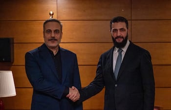 El ministro turco de Exteriores, Hakan Fidan (d) saluda al presidente de Siria, Ahmed al Shara'a, durante un foro diplomático en Turquía.