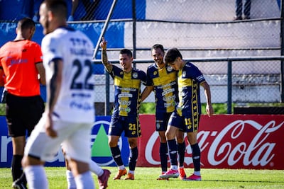 El delantero del Sportivo Trinidense, Clementino González celebra el tanto de apertura en el marcador, en medio de Gustavo Viera y Luis Carlos Abreu. (Foto: APF)