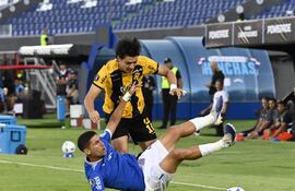 Derlis Rodríguez, de Guaraní, intenta salir de la marca de Federico Barrandeguy quien cae para oponer el avance en Sajonia.