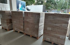 Cajas apiladas y envueltas en plástico en un almacén, sin personas visibles ni texto identificable.