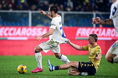 El delantero islandés de Génova #11 Albert Gudmundsson (R) tira la camiseta del centrocampista armenio del Inter de Milán #22 Henrikh Mkhitaryan durante el partido de fútbol de la Serie A italiana entre Génova y el Inter de Milán en el estadio Luigi Ferraris de Génova, el 29 de diciembre de 2023