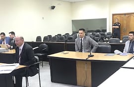 El piloto Fredy Garcete declarando en el juicio oral al senador cartista Erico Galeano (der.)