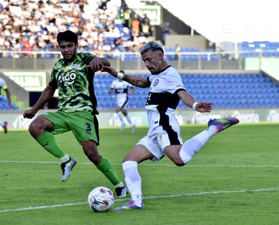 Iván Leguizamón, jugador de Olimpia, disputa el balón con Robert Rojas (i), futbolista de Libertad, en el partido por la octava fecha del torneo Clausura 2025 de la Primera División de Paraguay en el estadio Defensores del Chaco, en Asunción, Paraguay.