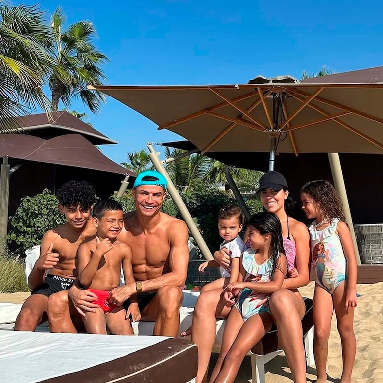 Cristiano Ronaldo sonríe en la playa con pantalones cortos, rodeado de la familia