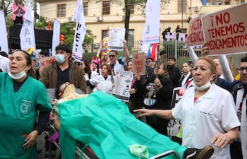 Un grupo de médicos participa en una protesta, en Asunción. Médicos del sector público marcharon y protagonizaron concentraciones en Paraguay, en el primer día de una huelga general que han convocado hasta el viernes para exigir un reajuste salarial, mejores condiciones laborales y la dotación de insumos y medicamentos en los hospitales. EFE/ Nina Osorio