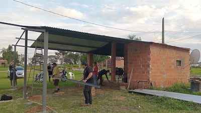 Un grupo de vecinos trabajan en el mejoramiento de la caseta de seguridad del barrio y otras obras de la comunidad