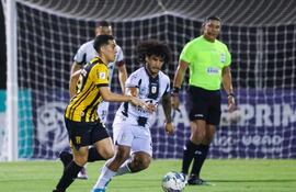 El aborigen Nicolás Barrientos traslada el balón  ante la marca  de Alfredo Amarilla, anoche en Dos Bocas.