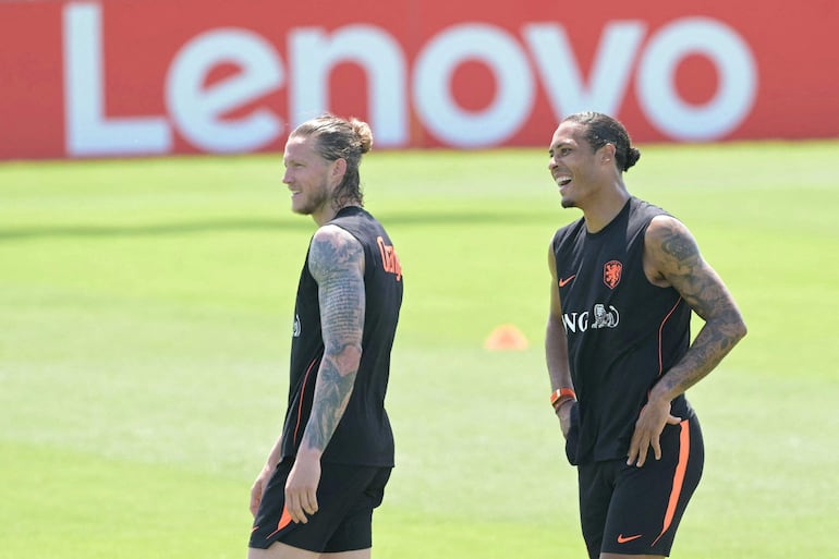 El delantero de los Países Bajos Wout Weghorst (izq.) y el defensor Virgil van Dijk sonríen durante una sesión de entrenamiento en el centro de entrenamiento del KC Current en Kansas City
