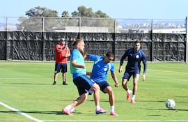 Fútbol reducido esta tarde en San José, llegan a la disputa del balón Isidro Pitta y Víctor Gustavo Velázquez, más al fondo Antonio Sanabria observa el cruce.