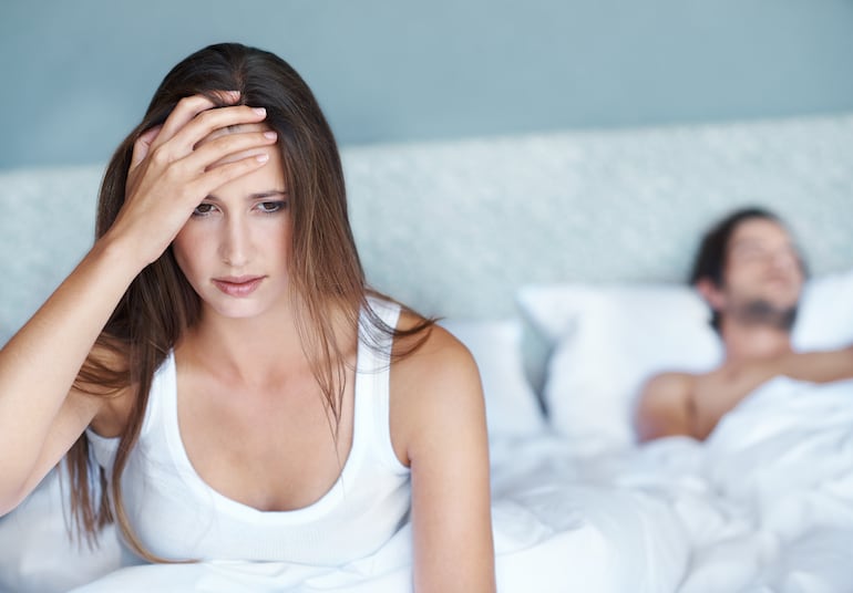 Pareja en la cama. Mujer con dudas, culpa, etcétera. Imagen ilustrativa.