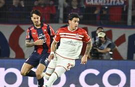 El volante de Estudiantes, Alexis Castro maneja el esférico ante la presencia cercana del uruguayo Fabricio Domínguez Huertas.