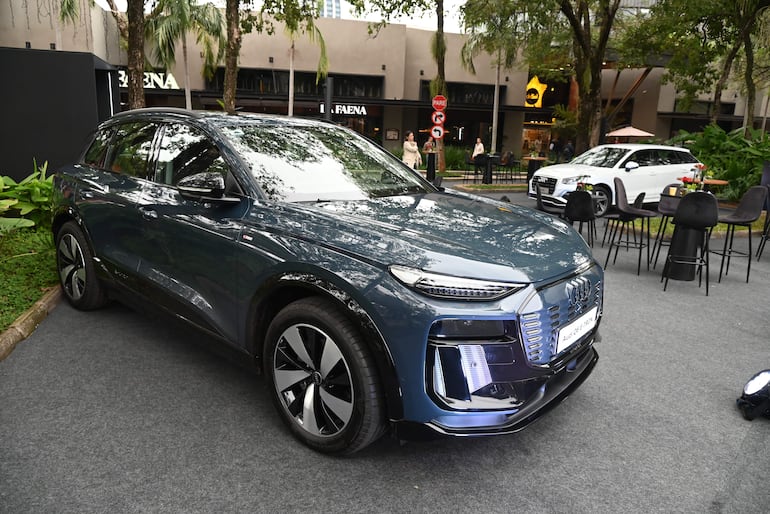 Vehículo SUV azul oscuro estacionado en un entorno urbano con mesas dispuestas, sin personas presentes.