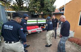 El chofer del camión incautado, Marciano Ariístides Araujo Ávalos (esposado), observa a los agentes cuando abren el doble fondo de la carrocería, donde estaban ocultos los paquetes, durante el procedimiento de rigor.