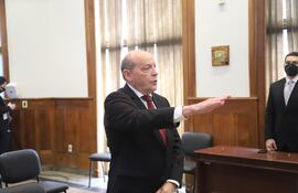 Cesar Manuel Diesel en traje oscuro y corbata roja, gesticulando en un discurso formal con otra persona observando a su lado.