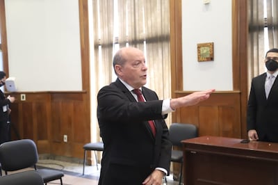 Cesar Manuel Diesel en traje oscuro y corbata roja, gesticulando en un discurso formal con otra persona observando a su lado.