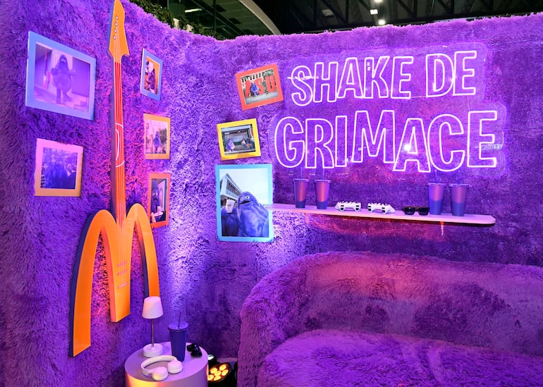 Ambiente decorado en púrpura con logo de McDonald's y vasos de plástico; sin personas presentes.
