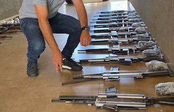 El fiscal de Pedro Juan Caballero, Celso René Morales Fernández, con los fusiles de guerra incautados.
