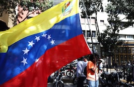 Un simpatizante del oficialismo sostiene una bandera de Venezuela este sábado en inmediaciones del Palacio de Miraflores en Caracas (Venezuela). Chavistas salieron a las calles del centro de Caracas para exigir que "devuelvan" al mandatario venezolano, Nicolás Maduro, luego de que el líder estadounidense, Donald Trump, anunciara la captura del gobernante suramericano en medio de un ataque con misiles durante la madrugada de hoy contra la capital venezolana y otras zonas del país.