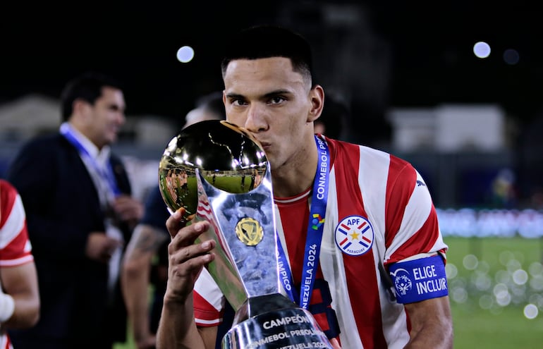 Diego Gómez, futbolista de la selección paraguaya, besa el trofeo de campeón del Preolímpico 2024 en los festejos en el estadio Nacional Brígido Iriarte, en Caracas, Venezuela.