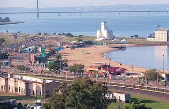 Panorámica costera en Encarnación, con un puente y un edificio singular. Ambiente tranquilo y recreativo, sin personas visibles.