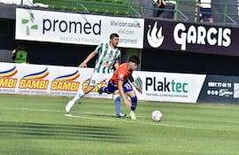El mediocampista del Sportivo 2 de Mayo Luis Delgadillo intenta conservar el esférico ante la marca del volante de Rubio Ñu, Rodrigo Rojas.