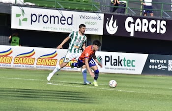 El mediocampista del Sportivo 2 de Mayo Luis Delgadillo intenta conservar el esférico ante la marca del volante de Rubio Ñu, Rodrigo Rojas.