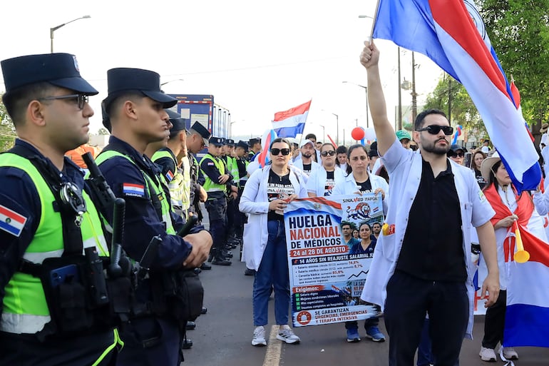 Un grupo de médicos participa en una manifestación en la que exigen un reajuste de salarios, dotación en los hospitales y mejores condiciones laborales este viernes, en Cambyretá (Paraguay). Los médicos, quienes están en huelga desde el pasado lunes, salieron a las calles del departamento paraguayo de Itapúa que es escenario del Campeonato Mundial de la especialidad (WRC) por segundo año consecutivo.