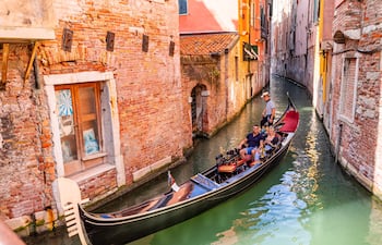 Góndola con turistas en Venecia, Italia.