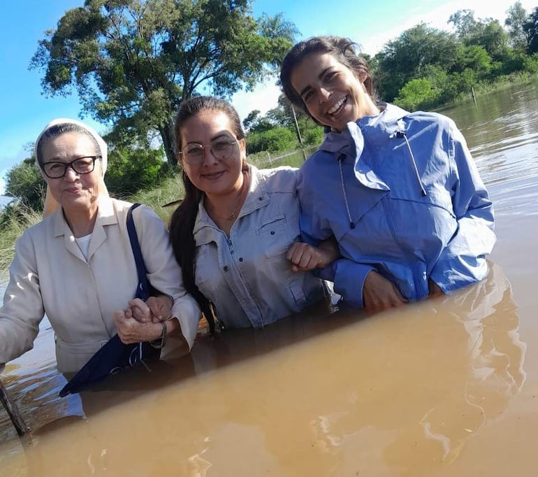 Las mujeres arriesgan la vida para evacuar a las familias afectadas por la inundacion.