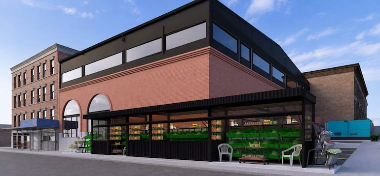 Edificio comercial moderno de ladrillo con grandes ventanales y estantes de productos en un entorno soleado.