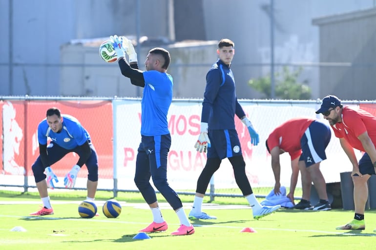 Roberto Junior Fernández, Gastón Olveira y Orlando Gill a un costado del campo haciendo trabajos específicos.