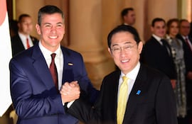 Fumio Kishida (der.) saluda a Santiago Peña, ayer en Palacio de López. (Photo by NORBERTO DUARTE / AFP).