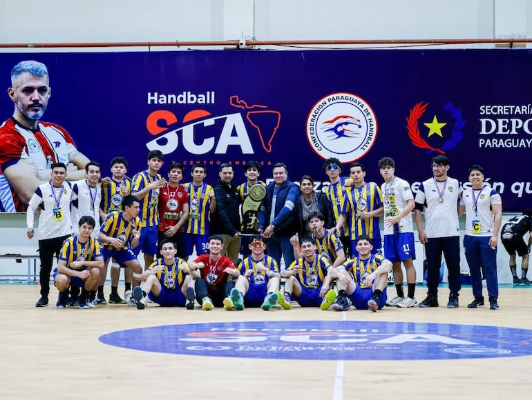 Nadyr Figueredo titular de la CPH y Martín Duarte Leite, secretario, entregan el trofeo al capitán luqueño Júnior, tras obtener el Apertura'26.