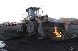 Tractores limpian escombros en la vía de La Paz con Oruro hoy, en Ventilla (Bolivia). El convoy de militares y policías de Bolivia que llevan banderas blancas en sus vehículos durante un nuevo operativo de desbloqueo de una carretera troncal de Bolivia afectada por protestas.